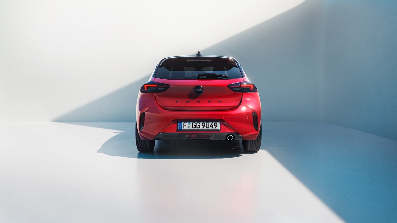Nowy Opel Corsa w czerwonym kolorze z czarnym dachem widziany z tyłu